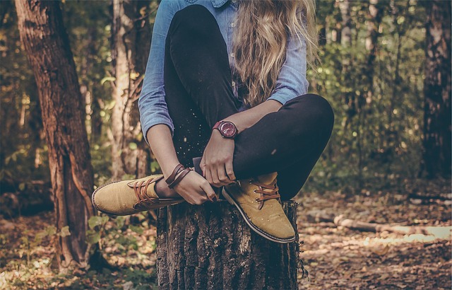 sedící žena na pařezu v lese